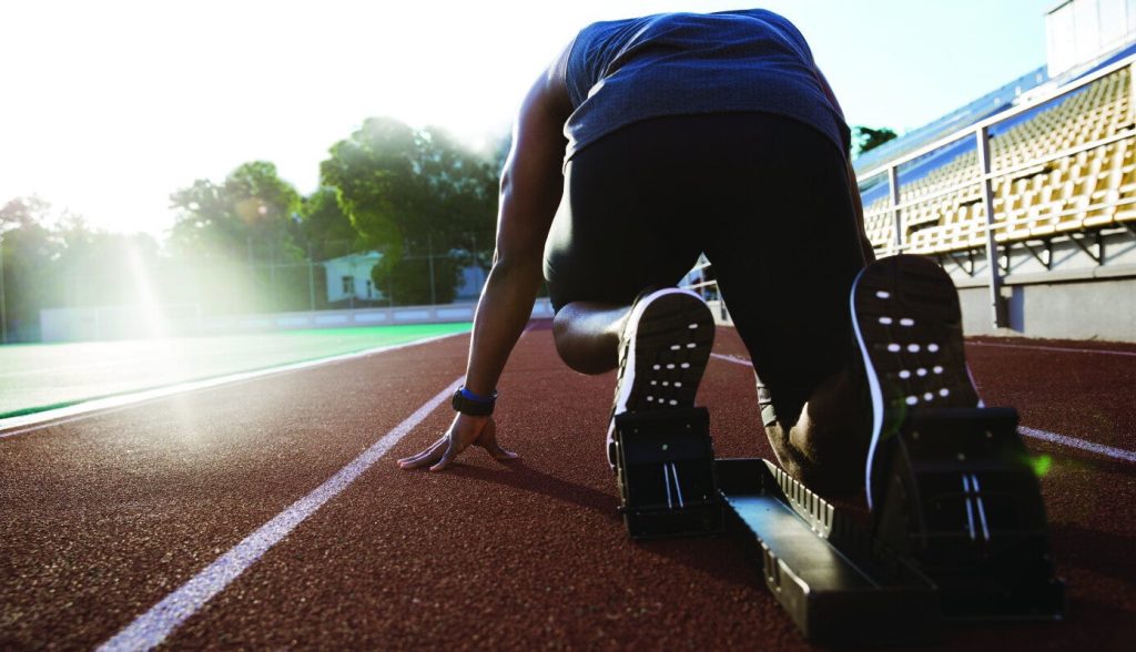 Atleta ai blocchi di partenza su una pista di atletica