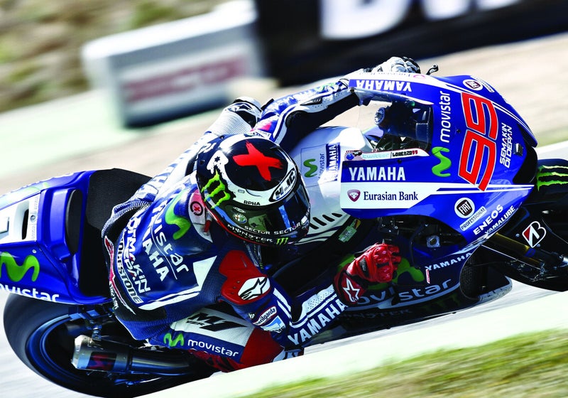 Pilota di MotoGP in piega con una moto sponsorizzata